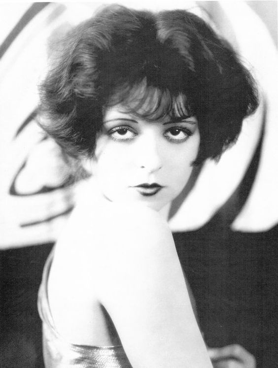 Clara Bow, one of the 3 most famous flappers, represents perfect flapper face and figure. Big - eyed, baby - faced flapper image. 