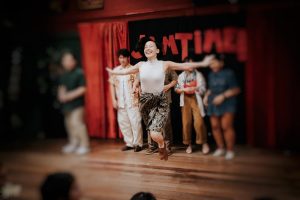 photo of young female swing dancer Atcha Lamlertpanya performing solo jazz dance at a swing dance event